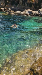 ragazzo fa snorkeling nella baia del mediterraneo
