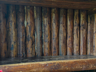 A weathered wooden wall and shelf create a rustic and inviting interior backdrop.