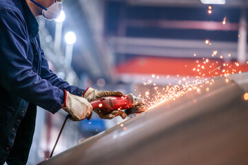 A man is using a power tool to cut metal