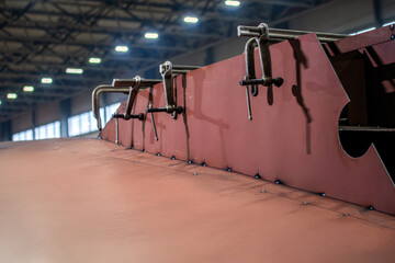 A red wall with metal clamps on it