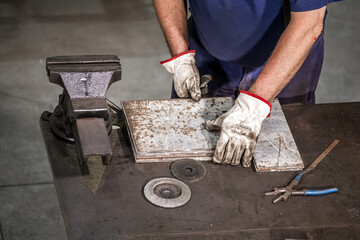 A man is working on a project with a metal file and a hammer