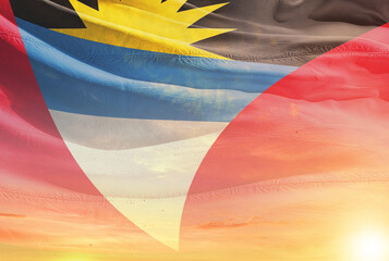 Antigua and Barbuda national flag waving in sunny sky with beautiful sunset. Antigua and Barbuda...
