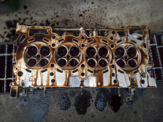 combustion chamber in the cylinder head of a gasoline engine vehicle being overhauled in a garage	