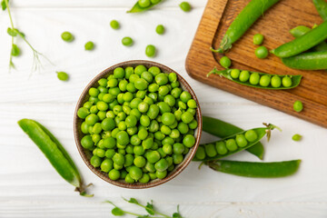 Fresh green pea pods with green peas on a wooden background. Sweet green peas. Green pea beans vegetables. Vegan. healthy vegetable. Copy space