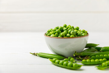 Fresh green pea pods with green peas on a wooden background. Sweet green peas. Green pea beans vegetables. Vegan. healthy vegetable. Copy space