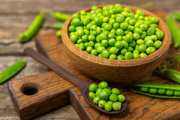 Fresh green pea pods with green peas on a wooden background. Sweet green peas. Green pea beans vegetables. Vegan. healthy vegetable. Copy space