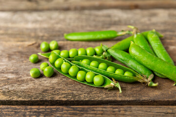Fresh green pea pods with green peas on a wooden background. Sweet green peas. Green pea beans vegetables. Vegan. healthy vegetable. Copy space
