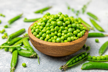 Fresh green pea pods with green peas on a wooden background. Sweet green peas. Green pea beans vegetables. Vegan. healthy vegetable. Copy space