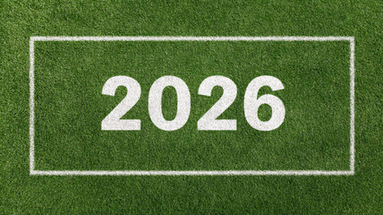 White painted 2026 number marking green soccer field surface, representing upcoming international sports competition