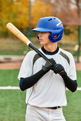 Good looking teenage boy preparing to hit a baseball on a sunny day at the field