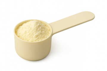 Plastic measuring spoon containing milk powder on transparent background