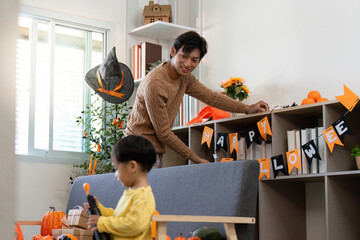 Halloween Fun. A father and son decorate together for Halloween with playful spirit.