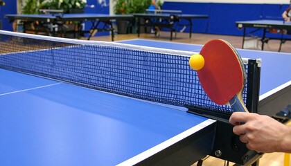 Close-up image showcases a ping pong ball hitting the net during a game