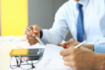 Business professionals engaged in a collaborative discussion while reviewing documents at a modern office setting