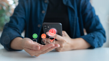 Close-up of a person selecting a smiley face on a smartphone screen with emotion-based feedback icons. Concept of mobile user satisfaction survey, customer review system, and UX interface design.