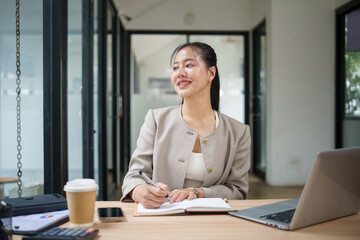 Confident female executive thinking creatively during work in a contemporary workspace.