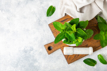 Fresh mint with mortar and pestle on wooden background. Melissa leaves. Healing herbs green mint leaves in mortar for medicine.Space for text. Copy space.