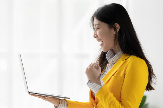 Dedicated Asian woman using laptop, analyzing financial data, working at desk, freelancer, online marketing, ecommerce, telemarketing concept.