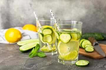 Cucumber water with lemon, lime and mint on a wooden table. Water infused with sliced...