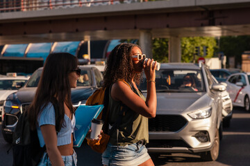 Teenage girls crossing street with school essentials