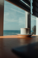 hot cup of coffee on the table in the morning, relaxing time, by the window