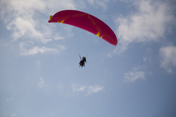 Persone su paracadute rosso per parapendio