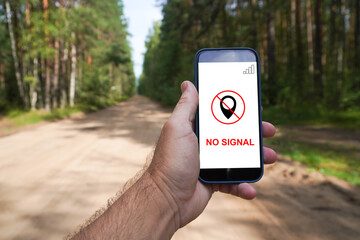 Man holding smartphone showing no signal in forest road. travel and tourism without cellular...