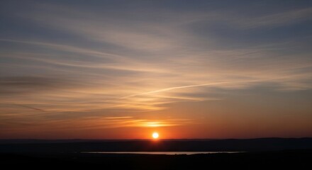 Obraz premium Serene sunset over hills and lake with vibrant sky colors