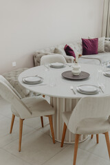 Elegant modern dining area with white round table and four chairs in bright room