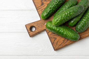 Cucumber on wooden background. Slice of cucumber on background. Fresh organic green cucumbers gherkin. Vegan. Salad ingredient. Farm vegetables. Cut vegetables with knife. Space for text. Copy space