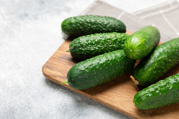 Cucumber on wooden background. Slice of cucumber on background. Fresh organic green cucumbers gherkin. Vegan. Salad ingredient. Farm vegetables. Cut vegetables with knife. Space for text. Copy space