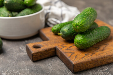 Cucumber on wooden background. Slice of cucumber on background. Fresh organic green cucumbers gherkin. Vegan. Salad ingredient. Farm vegetables. Cut vegetables with knife. Space for text. Copy space