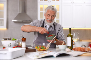Elderly man cooking at table in kitchen