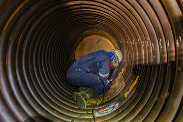Welding male worker metal is part of machinery boiler coil tank construction repair inside