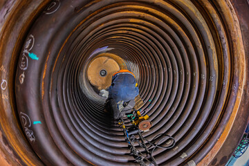 Welding male worker metal is part of machinery boiler coil tank construction repair inside