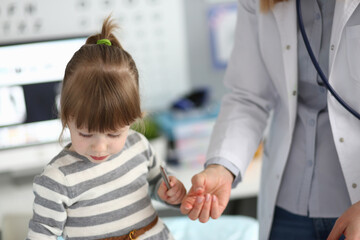 Young child interacting with a caring medical professional in a bright clinic during a routine health check-up