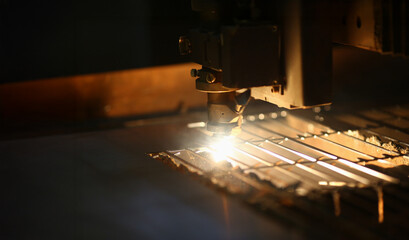 Incandescent light illuminates focused cutting process in a workshop during dusk hours