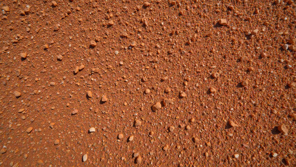 Textured surface reddish soil small stones natural material earthy background outdoor environment abstract pattern granular detail