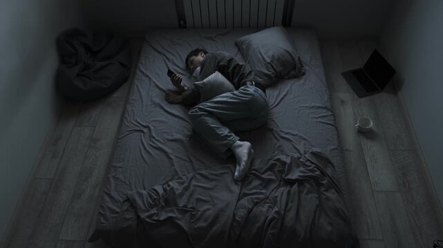 Broken heart after breakup. Young man looking at ex girlfriend social media unable to cope with pain and throws phone away.