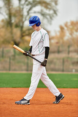 Talented teenage boy practices baseball on a sunny field while showcasing his skills