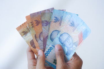 Hand gesture of counting Indonesian rupiah banknotes, closeup