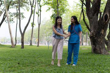 A friendly nurse assists an elderly woman in a wheelchair, providing care, support, and...