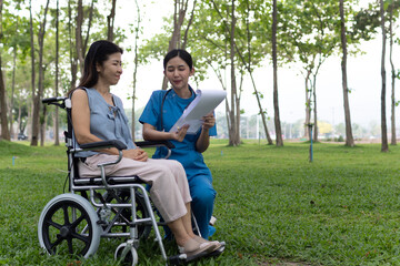 A friendly nurse assists an elderly woman in a wheelchair, providing care, support, and...