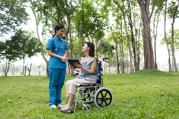 A friendly nurse assists an elderly woman in a wheelchair, providing care, support, and...