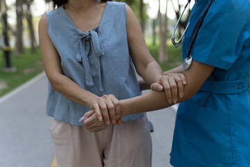 A friendly nurse assists an elderly woman in a wheelchair, providing care, support, and...