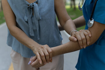 A friendly nurse assists an elderly woman in a wheelchair, providing care, support, and...
