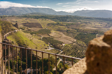 View from the railing of a viewpoint high above a mountain village, overlooking beautiful rural...