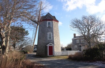 Gray windmill, red door, winter scene
