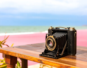 Vintage Black Camera on Wooden Table at Pink Sand Beach