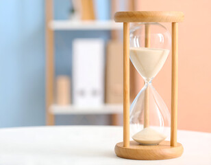 Wooden Hourglass on White Table with Soft Lighting and Pastel Background